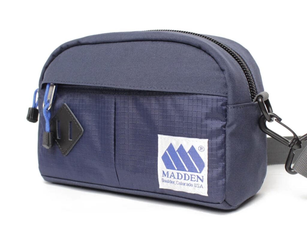 MADDEN Altona Hip Pack (2L) in navy blue, shown styled across the chest on an urban street for a modern, minimalist look
